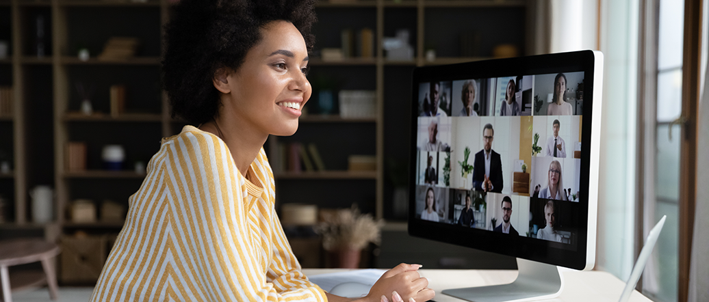 Person working on a desktop computer showing participants on a webinar screen