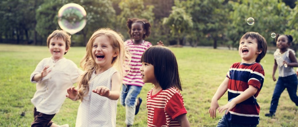 Children playing outside in the grass